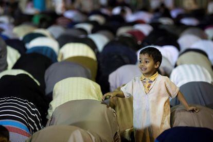 Un niño sonríe mientras los mayores participan en unas oraciones nocturnas llamadas Traweeh, durante la 27ª noche del mes sagrado del Ramadán en una mezquita de Hay Inbiaat, Sale, a las afueras de Rabat (Marruecos).