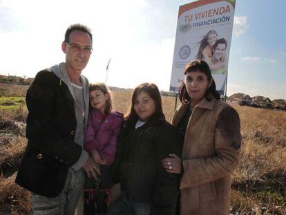 José Luis Blanco y Ruth Cuadrado, con sus dos hijas, junto al anuncio de una promoción inmobiliaria en Villanueva de la Torre.