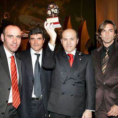 El presidente del Sevilla, Jose María Del Nido, sostiene, junto a Monchi, Juande Ramos (entrenador) y Javi Navarro, el trofeo que acredita al Sevilla como mejor equipo del mundo en 2006.
