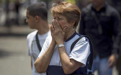 Una mujer se cubre el rostro de los gases lacrimógenos en Caracas.