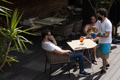 Un camarero sirve unas bebidas a clientes de un hotel de Barcelona.
