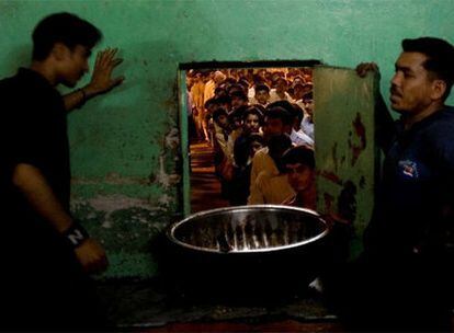 Dos voluntarios paquistaníes esperan la llegada de la comida que va a ser repartida entre la población en una mezquita de Islamabad.