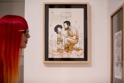Una mujer observa las viñetas originales del dibujante Isaac Sánchez expuestas en la galería El Arte del Cómic.