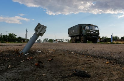 Un vehículo militar ruso pasa al lado de una munición sin explotar en la localidad ocupada de Chornobaivka, en la región de Jersón, en el sur de Ucrania, el martes.