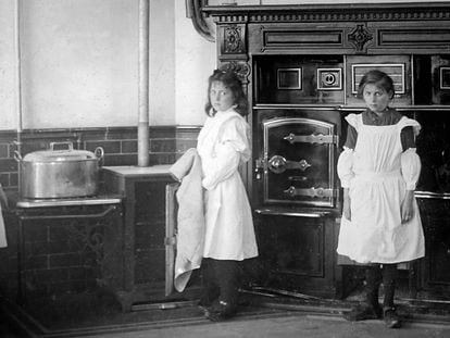 Dos niñas posan en la cocina de la casa en la que trabajaban como criadas, en una imagen fechada en la época victoriana.