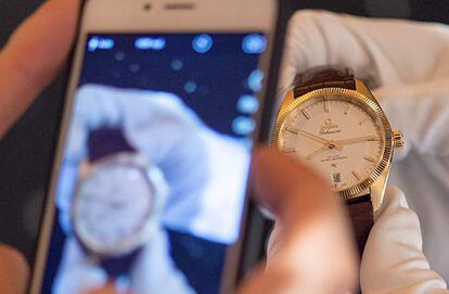 Un hombre hace una foto a un reloj.