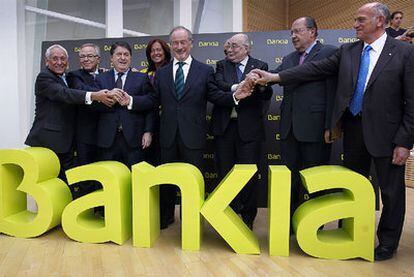 Rodrigo Rato, en el centro, junto a José Luis Olivas, vicepresidente del Banco Financiero y de Ahorros, a su derecha, y otros directivos durante la presentación de la marca Bankia, ayer en Valencia.