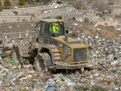 Una excavadora trabaja sobre la basura del vertedero.