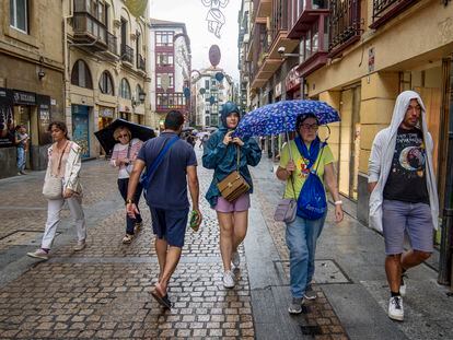 Varias personas se protegen de la lluvia en Bilbao, este viernes.
