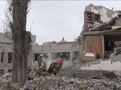 Trabajadores retiran los escombros de un colegio destruido por los bombardeos en Ucrania.