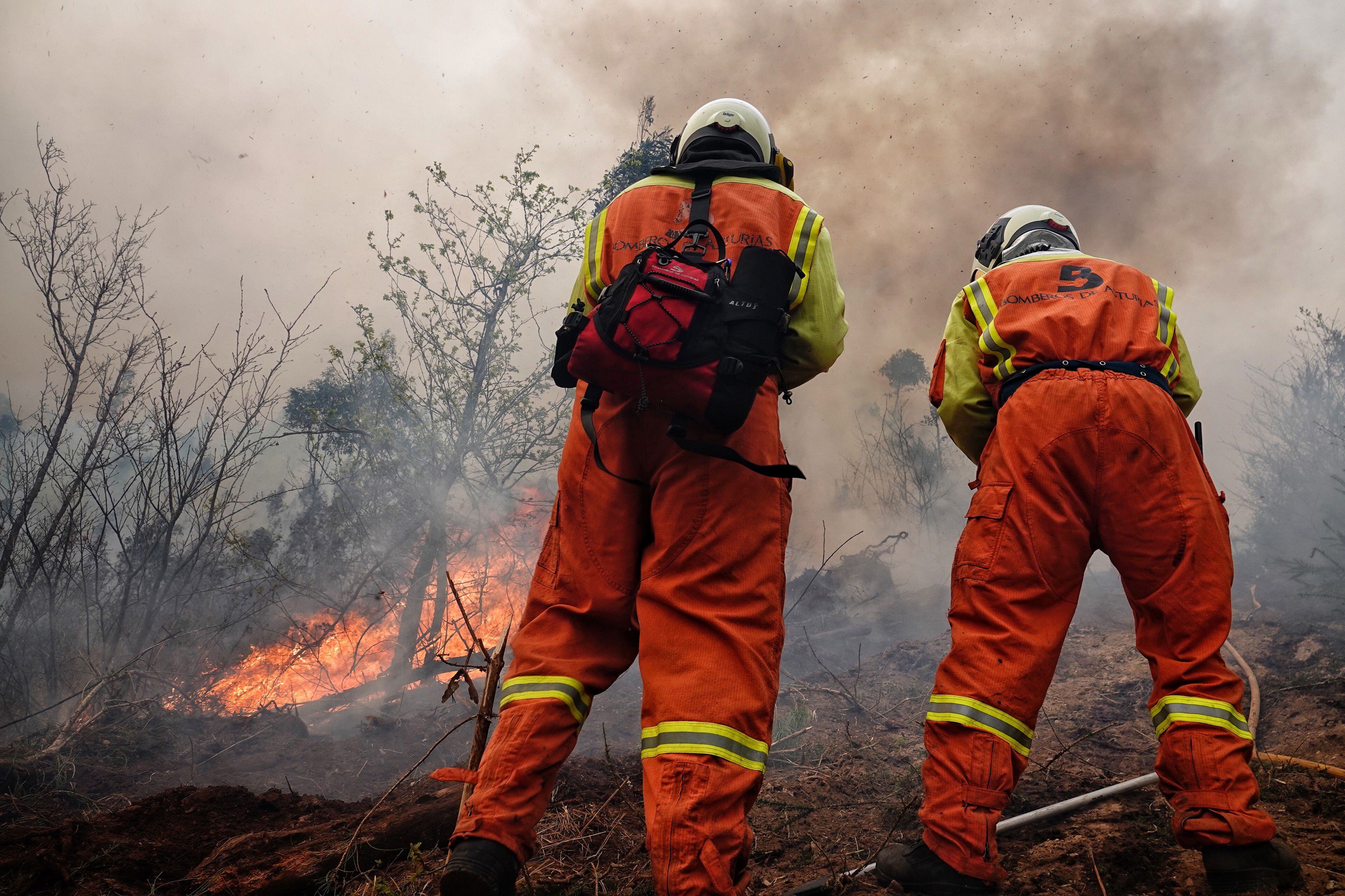 Bomberos trabajan en el incendio de los concejos asturianos de Valdés y Tineo, el jueves.