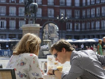 Dos turistas en la plaza Mayor.