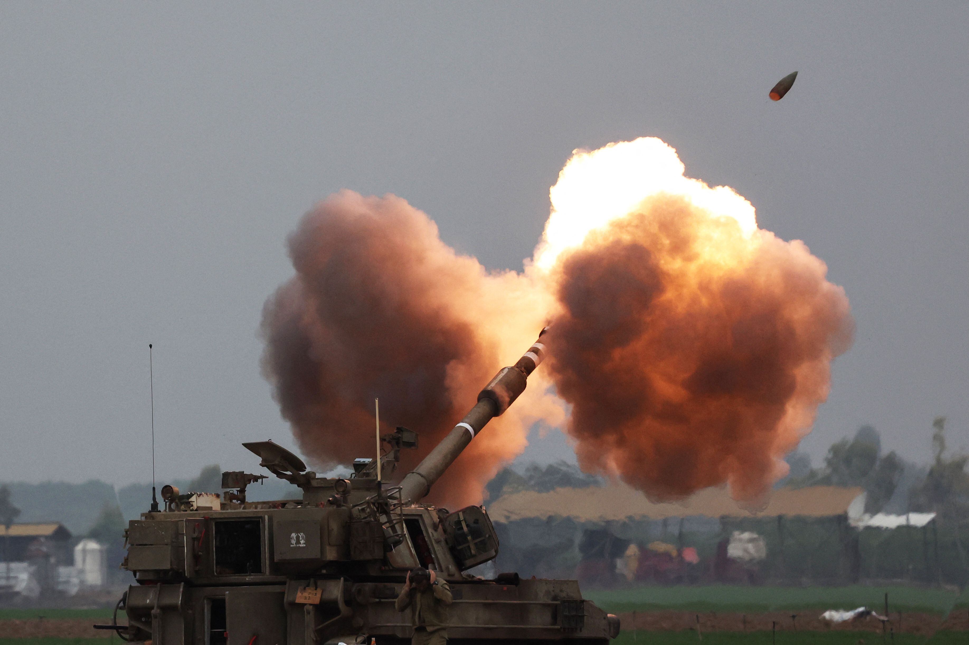 An Israeli army tank shells the Gaza Strip from the border area in southern Israel on December 14, 2023 amid ongoing battles with the Palestinian Hamas movement. Israel continued bombing Gaza on December 14 as a top White House adviser travelled to Jerusalem with a rift growing over civilian casualties. (Photo by JACK GUEZ / AFP)