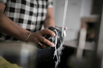 A woman washes some dishes in an apartment in Barcelona, ​​in an archive image.