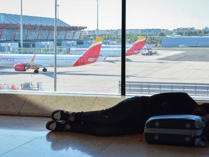 Una persona descansa en el Aeropuerto de Madrid Barajas, en una imagen de archivo.