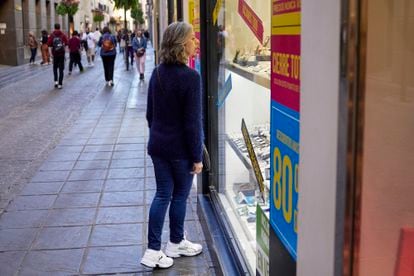 Una mujer observa un escaparate en una calle del centro de Granada.