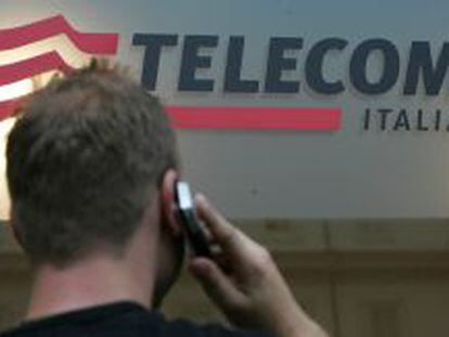 Un hombre hablando por el m&oacute;vil frente a una tienda de Telecom Italia.