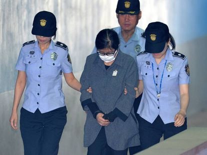 Choi Soon-sil, escoltada por la polic&iacute;a a su llega al tribunal que la ha juzgado en Se&uacute;l. 