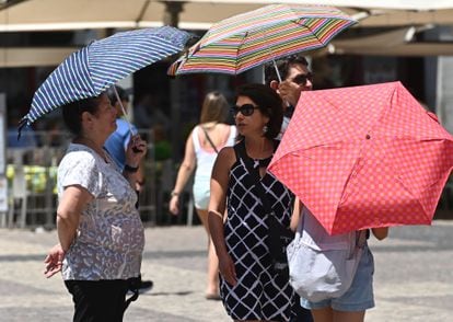 Varias personas pasean con una sombrilla por el centro de Madrid, el pasado día 26.