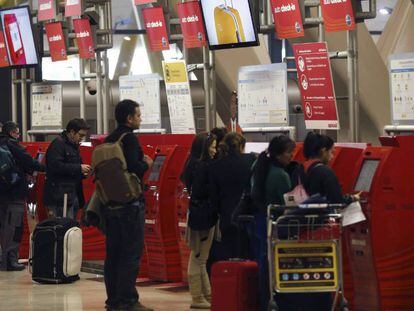 Varias personas, en los mostradores de facturaci&oacute;n de Iberia de la T4 del aeropuerto de Madrid-Barajas. 