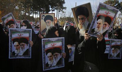 Un grupo de mujeres sostiene retratos del ayatolá Alí Jamenei y de su predecesor, Ruhollah Jomeini, en una protesta en la ciudad iraní de Qom.