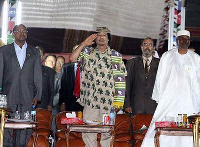 El líder libio, Muamar el Gaddafi (c), hace un saludo durante un desfile por el cuarenta aniversario de la revolución libia en Trípoli