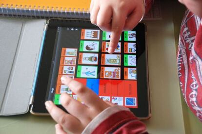 Un niño lee un cuento hecho con pictogramas.