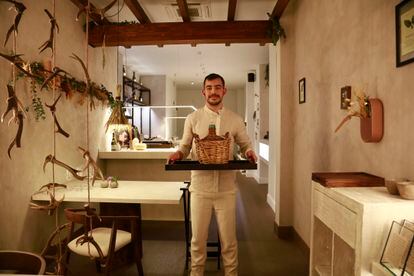 El chef Carlos Casillas con una damajuana, en el restaurante Barro, en Ávila.