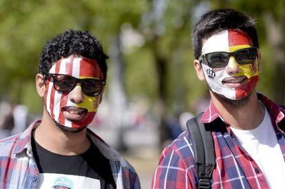Dos aficionados, uno del Atlético de Madrid y otro del Real Madrid, caminan con las caras pintadas por las calles de Lisboa.