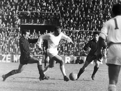 Di Stéfano escapa de los defensores ante la mirada de Gento en el Milán (2) - Real Madrid (0), en el partido de vuelta de cuartos de final de la Copa de Europa, en el estadio de San Siro.