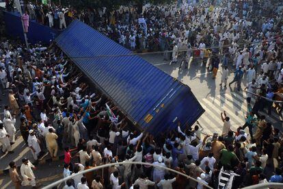 Manifestante mueven un contenedor en la ciudad pakistani de Lahore.