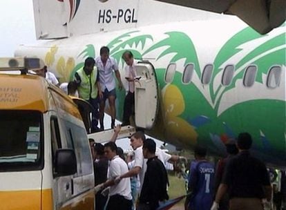 Trabajadores del aeropuerto de Koh Samui ayudan a los pasajeros a bajar del avión.