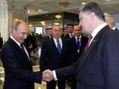 El presidente ruso, Vladimir Putin, da la mano al ucraniano, Petro Poroshenko.