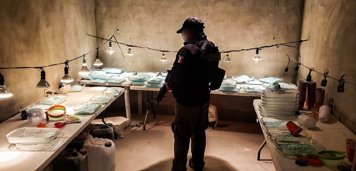 Un policía durante un cateo realizado en Tijuana en el que se decomisaron alrededor de 306.000  pastillas de fentanilo.