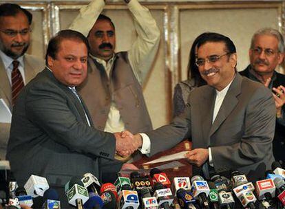 Nawaz Sharif, a la izquierda, estrecha la mano de Zardari, tras firmar el pacto de Gobierno.