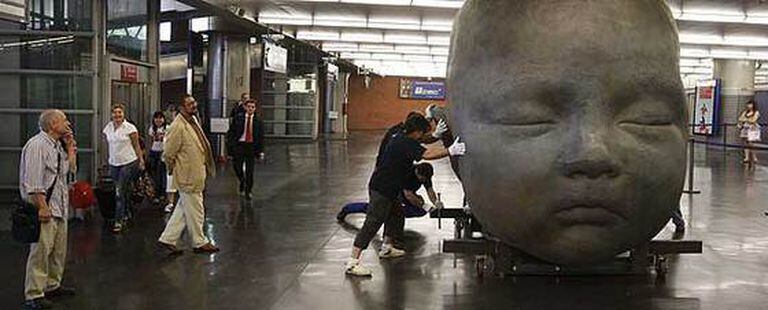 Antonio López, en primer plano a la izquierda, dirige la instalación de las esculturas en la estación de Atocha.