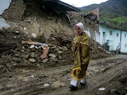 Una mujer camina frente a una casa que resultó dañada por un terremoto en Quetame, al sureste de Bogotá, el 25 de mayo de 2008.