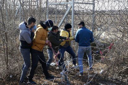 Varios migrantes intentan cortar la valla en la frontera turco-griega, el 2 de marzo.