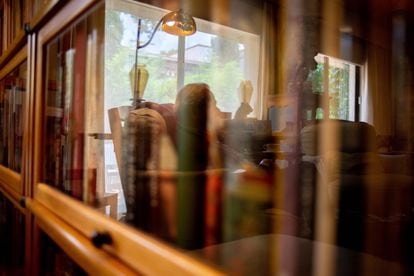 The writer and academic Gonzalo Celorio reflected in the display case of his library, with more than 12,000 volumes. 