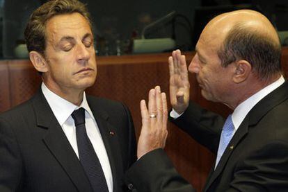 El presidente francés, Nicolas Sarkozy, charla con el presidente rumano, Trian Basescu, hoy en Bruselas.