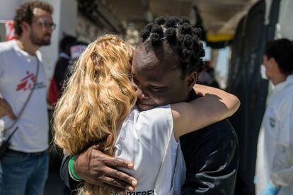 Una migrante se abraza a un miembro del buque 'Aquarius' durante su desembarco en el puerto de Valencia.