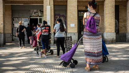 Un grupos de mujeres espera su turno en un local del Banco de Alimentos en el barrio de Orcasitas, Madrid.