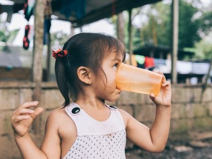 Una niña bebe agua potabilizada en San Fernando de Orellana, Ecuador.