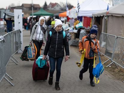 Una familia de refugiados ucranios cruza el campamento de Medyka (Polonia).