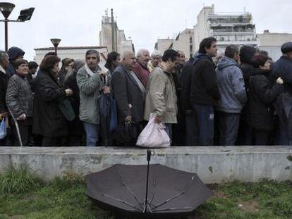Ciudadanos esperan para recibir comida gratuita, en Atenas.