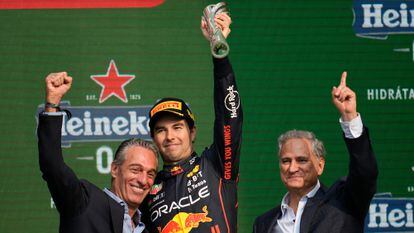 El padrino de Checo Pérez, Carlos Slim Domit, y Alejandro Soberón, encargado el Gran Premio mexicano, celebran con el piloto de Red Bull. 