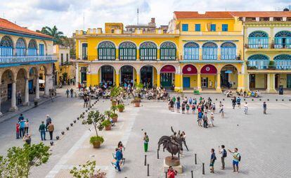 Turistas y cubanos paseando por la plaza Vieja, en La Habana Vieja.