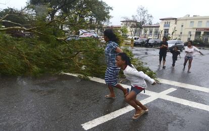 Según el último balance de las autoridades, unas 700.000 personas se han visto afectadas en el centro del país, donde la tormenta ha causados importantes cortes eléctricos, ha obligado a cancelar vuelos y cerrar aeropuertos y también a suspender las clases. Residente de Cebu intentan protegerse del viento, 8 de noviembre de 2013.