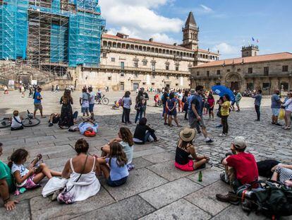 Turistas descansan en la plaza del Obradoiro en Santiago de Compostela.