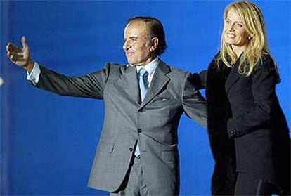 El candidato a presidente de Argentina Carlos Menem, junto a su mujer, Cecilia Bolocco, durante un mítin en Buenos Aires el pasado jueves.
